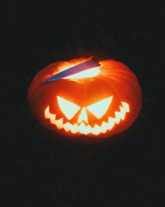 Illuminated Jack-o'-Lantern with knife creating a spooky Halloween atmosphere.